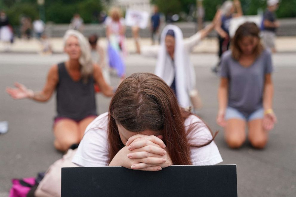 PHOTO: People pray outside the Supreme Court in Washington, D.C., on June 27, 2022 following the decision for former coach in public school prayer case.